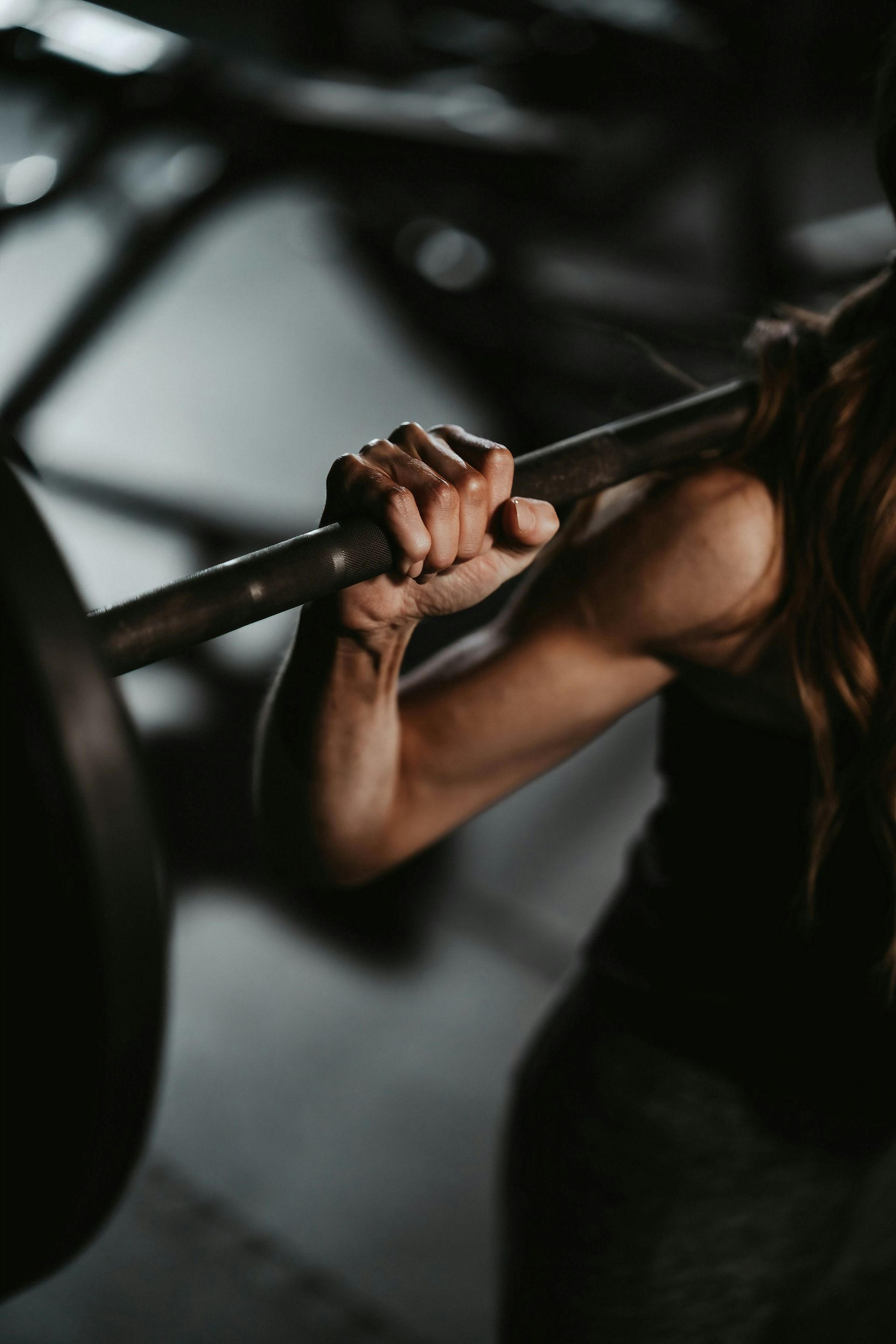 A woman lifting a barbell in a gym